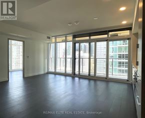 Toronto (Waterfront Communities) condo for rent - A spacious room with a view of the city through large windows.