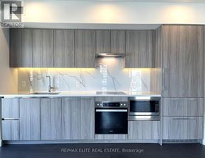 Toronto (Waterfront Communities) condo for rent - A modern kitchen with wooden cabinets and stainless steel appliances.