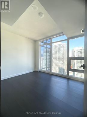 Toronto (Waterfront Communities) condo for rent - A room with a large window and a view of a city skyline.