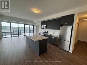 Clarington (Bowmanville) condo for rent - A kitchen with a refrigerator, sink, and stove top oven.