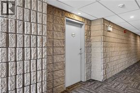 Guelph condo for rent - A hallway with a door and a wall with a pattern of squares.