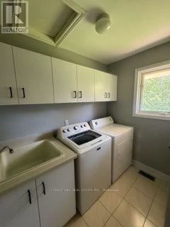 East Garafraxa apartment for rent - A small kitchen with a sink, stove, and cabinets.