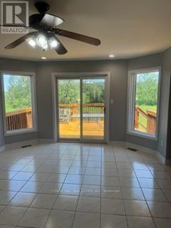 East Garafraxa apartment for rent - A room with a ceiling fan and sliding glass doors leading to a deck.
