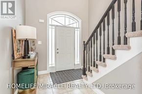 Kitchener apartment for rent - A hallway with a staircase, a door, and a table with a lamp on it.