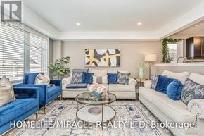 Kitchener apartment for rent - A living room with a white couch, blue chairs, and a coffee table.