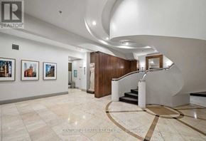 Toronto (Waterfront Communities) condo for rent - A hallway with a staircase and artwork on the wall.