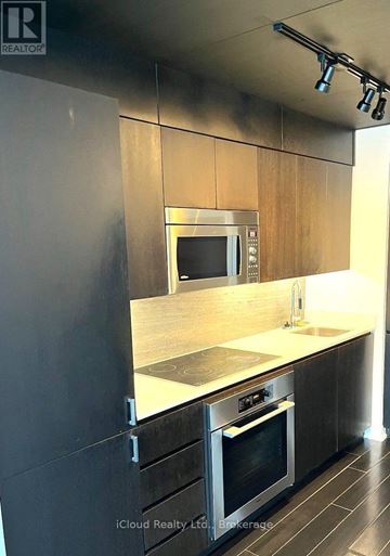 Toronto (Waterfront Communities) condo for rent - A modern kitchen with a stainless steel oven and microwave.