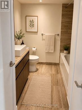 Toronto (Waterfront Communities) condo for rent - A bathroom with a toilet, sink, and a rug on the floor.