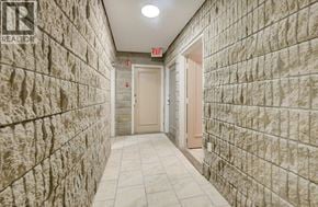 London apartment for rent - A hallway with stone walls and tile flooring.