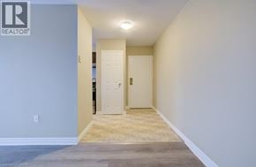 London apartment for rent - A hallway with a door on the right and a light switch on the wall.