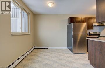 London apartment for rent - A kitchen with a stainless steel refrigerator and wooden cabinets.