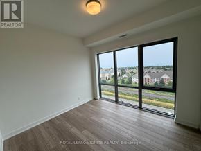Clarington (Bowmanville) condo for rent - A room with a large window overlooking a residential area.