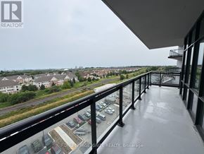 Clarington (Bowmanville) condo for rent - A balcony with a view of a parking lot and buildings.