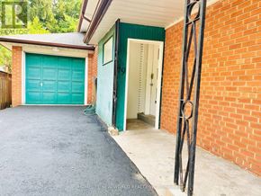 Toronto (Willowdale East) apartment for rent - A red brick house with a green garage door.