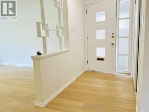 Toronto (Willowdale East) apartment for rent - A white door with a glass panel and a handle is in a room with wooden flooring.