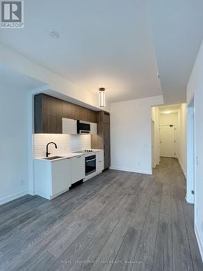 Richmond Hill (South Richvale) condo for rent - A modern kitchen with white cabinets and a wooden backsplash.