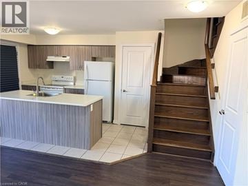 Toronto townhouse for rent - A kitchen with a refrigerator, sink, and stove.