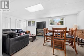 St. Catharines (Lakeport) apartment for rent - A living room with a black couch, a fireplace, and a television.