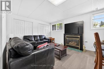 St. Catharines (Lakeport) apartment for rent - A living room with a black couch and a fireplace.