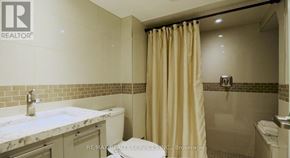 Mississauga (Mineola) apartment for rent - A bathroom with a marble countertop and beige shower curtain.
