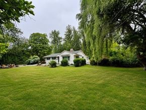 Langley apartment for rent - A white house with a green lawn in front.