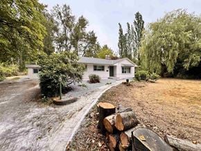 Langley apartment for rent - A house with a driveway and logs in front.