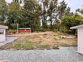 Langley apartment for rent - A gravel area with a red shed and trees in the background.