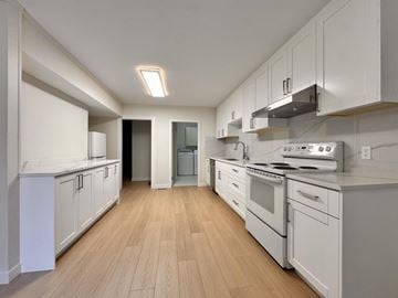 Langley apartment for rent - A kitchen with white cabinets and appliances.