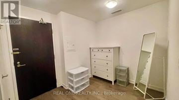 Toronto (Kensington-Chinatown) condo for rent - A bedroom with a white dresser and a black door.
