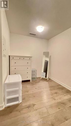 Toronto (Kensington-Chinatown) condo for rent - A white dresser with a white cabinet and a white chair in a room with wooden flooring.