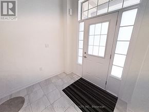 Pickering townhouse for rent - A white door with a glass panel is in a room with a black and white tiled floor.