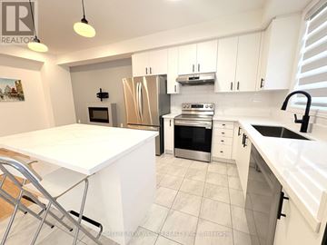 Pickering townhouse for rent - A white kitchen with a table and chairs.