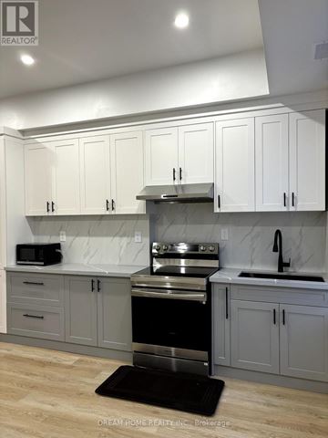 Toronto (Cabbagetown-South St. James Town) apartment for rent - A kitchen with white cabinets and a black stove top oven.