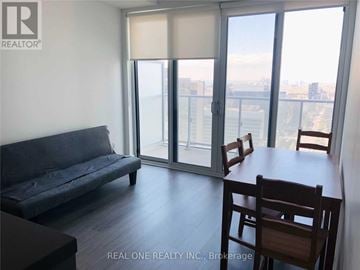 Toronto (Bay Street Corridor) condo for rent - A living room with a couch, table and chairs with a view of the city.