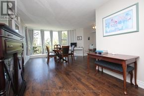 Toronto (Rouge) condo for rent - A living room with a wooden floor and a dining table.