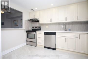Toronto (Rouge) condo for rent - A modern kitchen with white cabinets and stainless steel appliances.