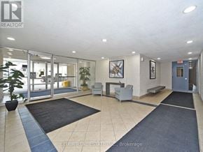 Toronto (Parkwoods-Donalda) condo for rent - A reception area with a plant, chairs, and a framed picture on the wall.