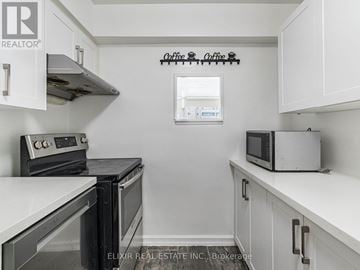 Toronto (Parkwoods-Donalda) condo for rent - A kitchen with white cabinets and a black stove top oven.