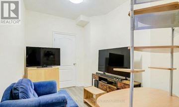 Vaughan (Patterson) apartment for rent - A living room with a blue couch and two TVs.