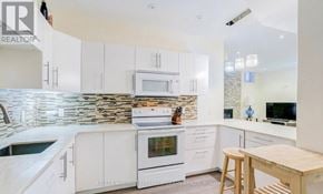 Vaughan (Patterson) apartment for rent - A kitchen with white cabinets and a stone backsplash.