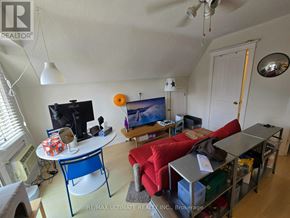Toronto (High Park-Swansea) multi-family for rent - A living room with a red couch and a television.