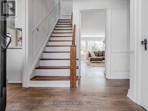 Burlington (Lasalle) apartment for rent - A wooden staircase with white walls and a doorway leading to a living room.