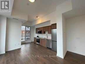 Kitchener condo for rent - A well-lit kitchen with wooden cabinets and stainless steel appliances.