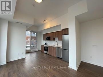 Kitchener condo for rent - A well-lit kitchen with wooden cabinets and stainless steel appliances.