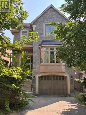 Toronto (Willowdale East) apartment for rent - A house with a stone facade and a large garage door.