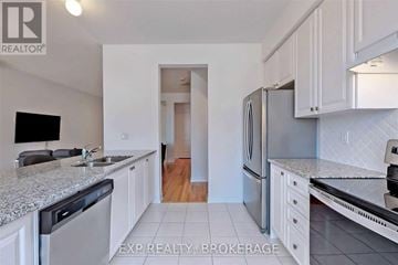 Brampton (Northwest Brampton) townhouse for rent - A kitchen with white cabinets and a granite countertop.