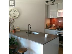 Vancouver apartment for rent - A modern kitchen with a stool and a clock on the wall.