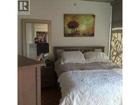 Vancouver apartment for rent - A bedroom with a bed, nightstand, and a painting on the wall.
