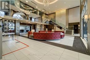 Toronto (Etobicoke West Mall) condo for rent - A large, well-lit lobby with a red patterned sofa and a staircase.