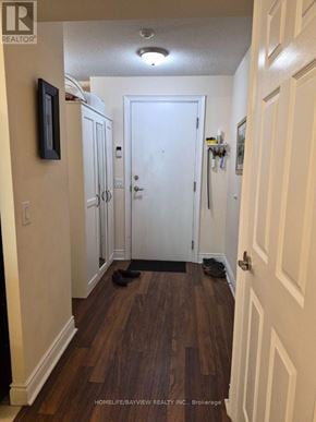 Toronto (Newtonbrook West) condo for rent - A hallway with a white door and a wooden floor.